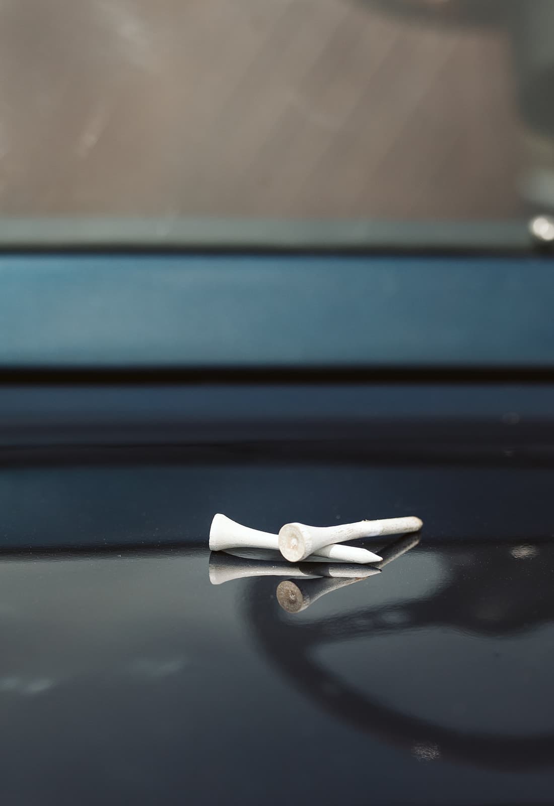 Golf tee lifestyle detail with cart behind